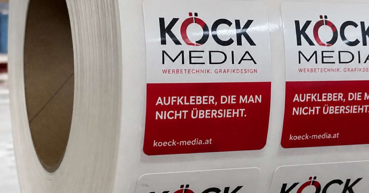 Aufkleberrolle mit KÖCK-MEDIA Stickern und dem Slogan „Aufkleber, die man nicht übersieht“ in der Produktion