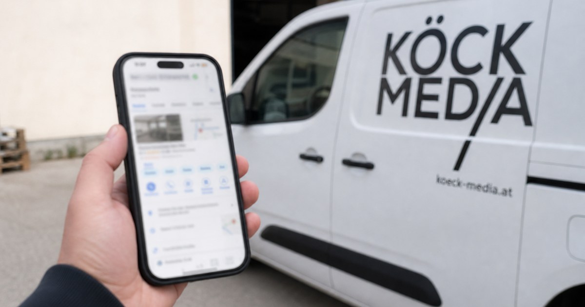 Beschriftetes Firmenfahrzeug vor einem Betrieb, im Vordergrund ein Smartphone mit geöffnetem Kartenprofil